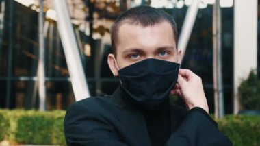 Karantina kavramı bitti. Adam şehir arka planında maskesini çıkarıyor. Güvendeyiz. Coronavirus bitti. Biz kazandık. Artık karantina yok. Derin nefes al. Maskeni çıkar.