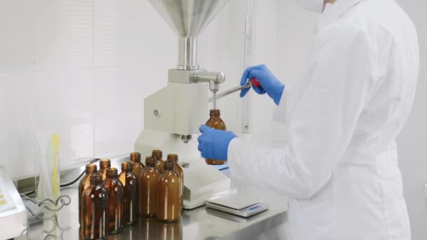 Ekspert kosmetologii, lekarz chemik, farmaceuta, produkujący kosmetyki medyczne w laboratorium. nalewanie i pomiar naturalnego płynnego serum balsamowego.Produkcja kosmetyków i perfum. — Wideo stockowe