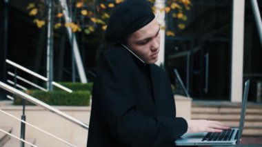 Kafkasyalı İşadamı Laptop Ofisi 'nde çalışırken telefonla konuşuyor.