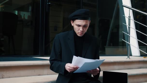 Un homme d'affaires concentré lisant des journaux d'affaires dans une rue urbaine. Homme travaillant sur les escaliers de la ville — Video