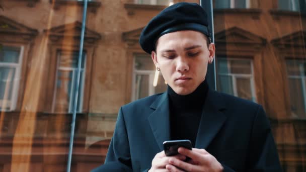 Um homem a usar o telefone na rua. Homem caucasiano jovem mensagens de texto, traindo seu Smartphone. Negócios. Redes sociais. Gente. Aplicações. — Vídeo de Stock