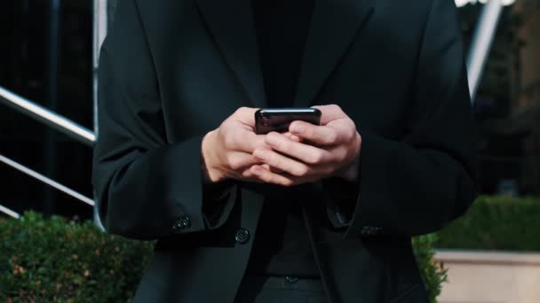 스마트폰 기기 문자 메시지를 사무실 밖에서 들고 있는 젊은 코카서스 남성, 소셜 미디어 서핑 웹 사이트에서 모바일 게임 채팅을 하는 앱을 사용하여 — 비디오
