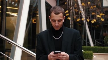 Beyaz adam telefonu kullanıyor ve sokaktan iyi haberler alıyor. Dışarıdaki telefonu kullanan bir iş adamı..