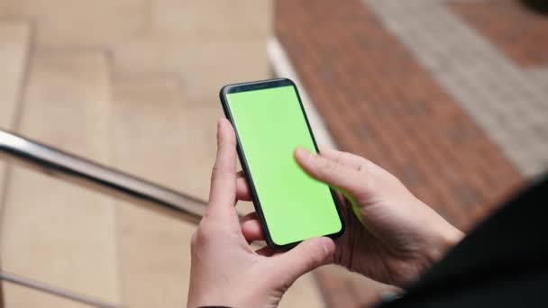 Männliche Hand vertikal halten Touchscreen-Smartphone Stadt-Attrappe bis Anzapfen Display grünen Bildschirm chromakey außen — Stockvideo