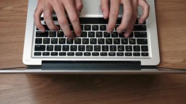 Ev ya da ofisteki masada oturan dizüstü bilgisayarda yazan elleri kapat.