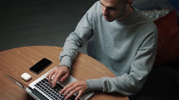 Jovem caucasiano freelancer homem trabalhando no computador em casa.Jovem profissional do sexo masculino usando computador sentado em casa — Vídeo de Stock