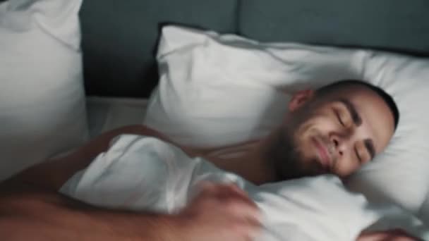 Happy smiling man sleeping peacefully on the bed. Adult Man going to sleep in bed, exhausting day, night rest. — Stockvideo