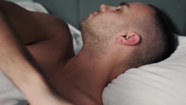 Homme caucasien fatigué dormant paisiblement sur le lit. L'homme va dormir au lit, épuisant jour, nuit de repos. — Video