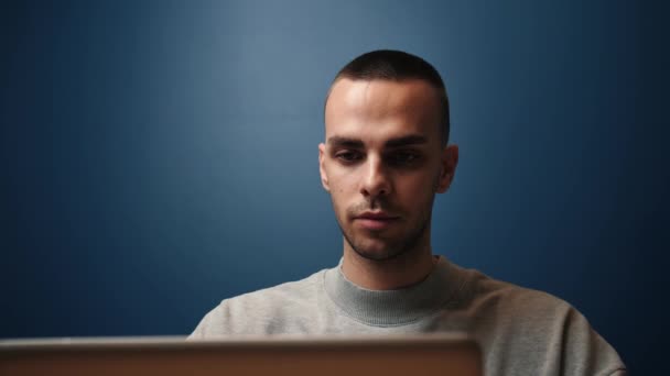 Un uomo d'affari caucasico concentrato lavora e digita su un portatile. Giovane professionista di sesso maschile che utilizza il computer portatile seduto alla scrivania di casa ufficio. — Video Stock