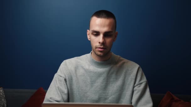 Confused caucasian man use laptop looking at screen shocked by received message or letter, man frustrated by unexpected bad news online, get negative news. — Vídeo de Stock