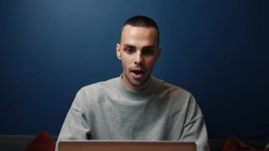 Gülümseyen beyaz adam evinde ya da ofisinde dizüstü bilgisayar kullanıyor. İyi haberleri okumak için heyecanlı bir profesyonel. Mutlu adam zaferin tadını çıkarıyor.