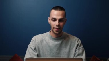 Gülümseyen beyaz adam evinde ya da ofisinde dizüstü bilgisayar kullanıyor. İyi haberleri okumak için heyecanlı bir profesyonel. Mutlu adam zaferin tadını çıkarıyor.