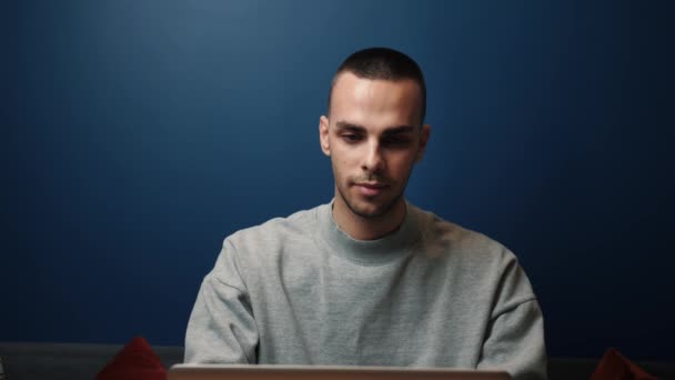 Den leende kaukasiske mannen använder en laptop hemma eller på kontoret. Spännande professionell läsning goda nyheter. Lycklig kille njuter av seger. — Stockvideo