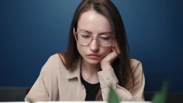 Sad woman working laptop computer at the home. An unhappy caucasian woman uses laptop at home. Worried girl stress at freelance work at the home workplace. Upset woman looking at laptop screen. Girl — Stock Video