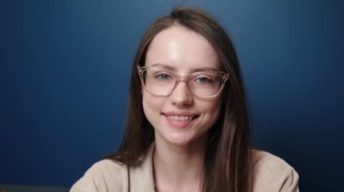 Mutlu bir portre gülümseyen genç çekici iş kadını kameraya bakıyor başarılı bir şekilde evde, yavaş çekimde yakın çekim