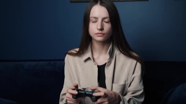 Žena hraje v noci doma videohru. Nudná hráčka sedí na gauči, hraje videohry na. — Stock video