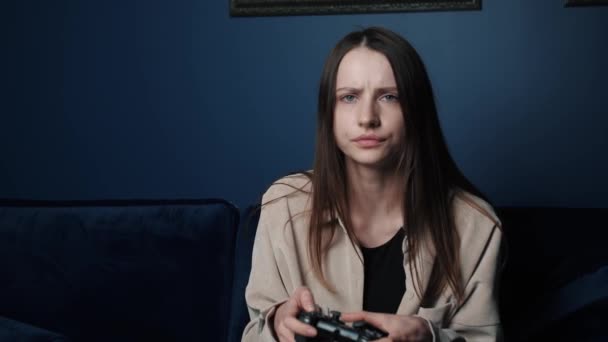 Žena hraje v noci doma videohru. Nadšený hráč žena sedí na gauči, hrát a prohrát ve videohrách na. — Stock video