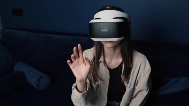 Mladá běloška v helmě VR dělá doma gesta rukou. Atraktivní žena těší virtuální realita kyberprostor. — Stock video