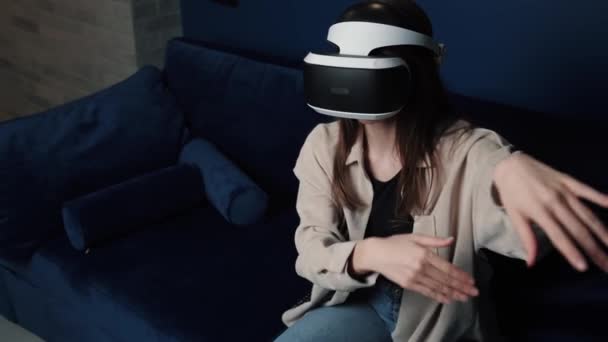 Mladá běloška v helmě VR dělá doma gesta rukou. Atraktivní žena těší virtuální realita kyberprostor. — Stock video
