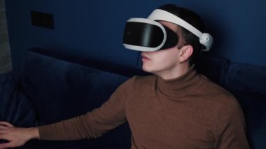 Kafkaslı bir adamın evde video oyunu oynamak için kulaklık kullandığı yavaş çekim videosu..