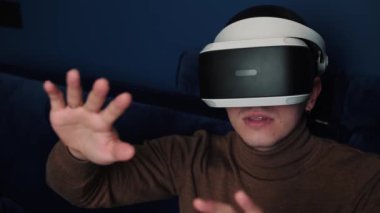 Kafkaslı bir adamın evde video oyunu oynamak için kulaklık kullandığı yavaş çekim videosu..
