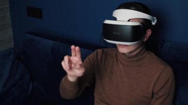 Kafkasyalı bir adamın evde video oyunu oynamak için kulaklık kullandığı yavaş çekim videosu. kaydırma kaydırma