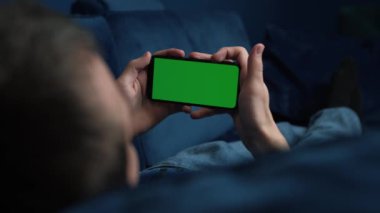 Geceleri krom renkli yeşil ekranlı akıllı telefon kullanan bir adam sosyal medya ya da internet dükkanında takılıyor. İnternet, haberleşme kavramı kapanıyor..
