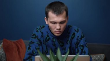 Kafkasyalı bir adam laptopta çalışıyor ve daktilo kullanıyor. Bilgisayarı kullanan genç profesyonel bir erkek ofis masasında oturuyor..