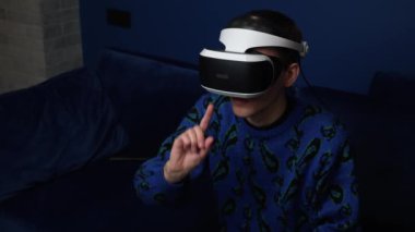 Kafkasyalı bir adamın evde video oyunu oynamak için kulaklık kullandığı yavaş çekim videosu. kaydırma kaydırma