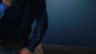 Evdeki kanepede telefonla konuşan yakışıklı beyaz adam. Portre adam evde dinleniyor ve akıllı telefondan sohbet ediyor.