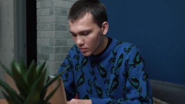 Odaklanmış yorgun bir genç adamın yatak haberleri var ve evde ya da ofiste bilgisayarını kullanıyor. Yorgun, beyaz bir adam telefon kullanıyor..