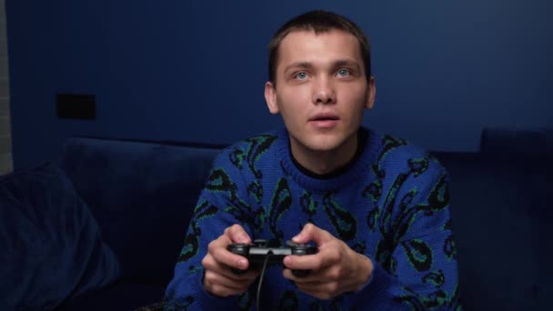 Přední pohled na vzrušeného bělocha, který hraje videohry a používá ovladač joystick. Šťastný muž hraje hry na pohovce doma. — Stock video