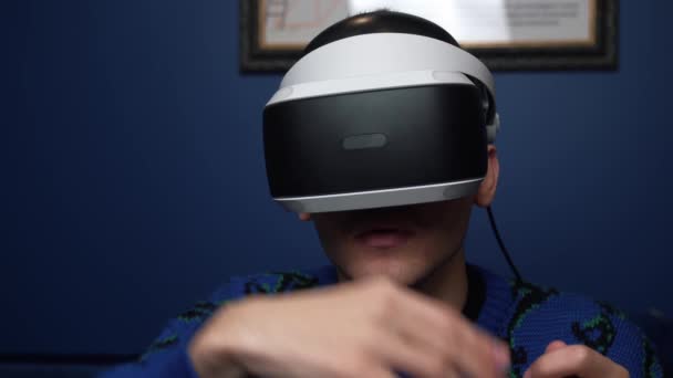 Close up Slow motion scene video dari seorang pria Kaukasia menggunakan perangkat helm VR headset untuk bermain video game di rumah. menggulung menggesekkan — Stok Video