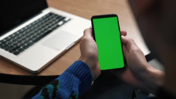 Detailní záběr telefonu se zelenou obrazovkou. Klávesa Chroma na obrazovce chytrého telefonu. Muž držící zelenou obrazovku telefonu a sledující video. Klikne a přejde. — Stock video