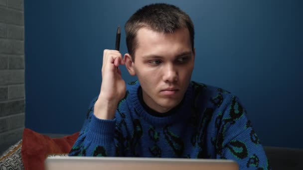 Удумливий серйозний молодий кавказький чоловік студент письменник сидить на домашньому офісному столі з ноутбуком, думаючи про натхнення пошук проблеми рішення ідеї втрачені в думках концепція мріяти озираючись — стокове відео