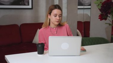 Evde dizüstü bilgisayarda çalışan güzel genç bir kadın, telefonla konuşuyor ve kötü haberleri var. Ağır çekim. Telefonda kötü haber veren kadın.. 