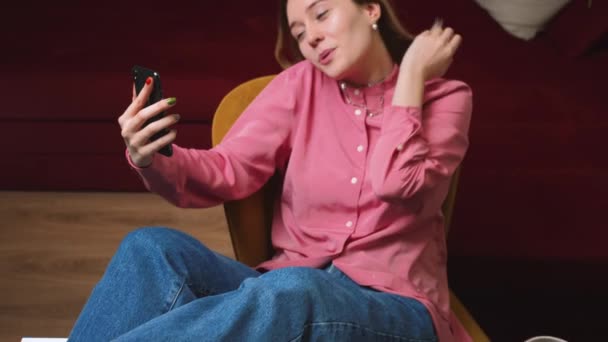 Mujer feliz hablando en el teléfono inteligente por chat de vídeo en casa. Mujer emocionada usando el teléfono para videollamada en el interior del hogar. Mujer de negocios sonriente haciendo gestos en la cámara del teléfono celular. — Vídeo de stock