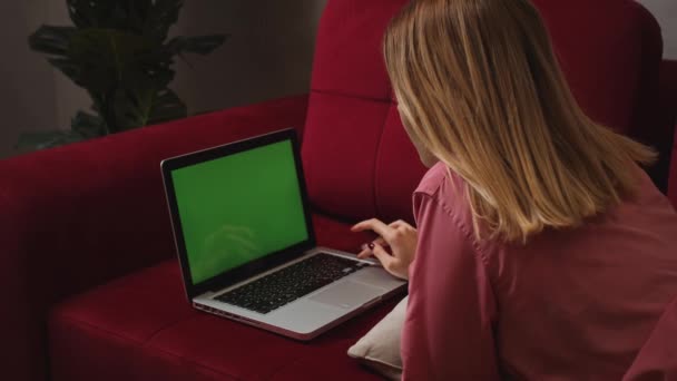 Zamknij uśmiechnięty bizneswoman leżące na kanapie i pracy laptopa zielony ekran chromakey w domu. Dziewczyny piszą na laptopie zielony ekran slow motion. Blisko kobieta freelancer przestał pracować na — Wideo stockowe