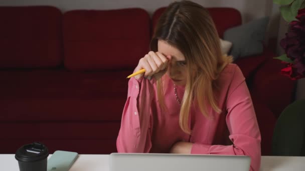 Zmęczony smutną twarzą biznesmenki patrzącej na laptopa w biurze. Zbliżenie zdenerwowanej kobiety myślącej o błędach w pracy. Portret smutnej dziewczyny wyglądającej jak laptop. Przygnębiony pracownik pracujący na laptopie. — Wideo stockowe