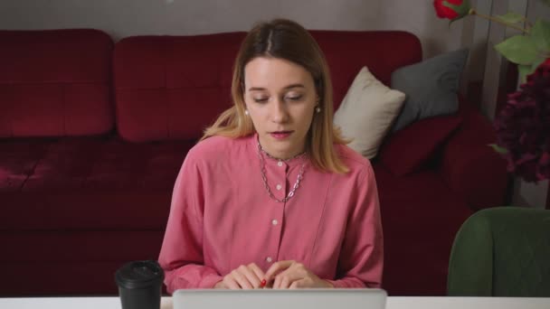 진지 한 여성이 인터넷으로 공부하고, 노트북을 보고, 집중하고 있고, 젊은 여성이 집에서 비디오 통화를 하고 있습니다.. — 비디오