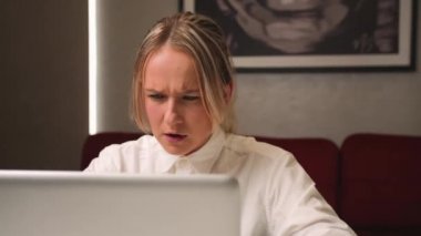 Ofiste dizüstü bilgisayara bakarken yorgun ve üzgün iş kadınının yüzünü kapat. İşindeki hataları düşünen üzgün bir kadına yaklaş. Laptop görünümlü üzgün kız portresi. Bunalımlı çalışan