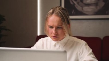 Ofiste dizüstü bilgisayara bakarken yorgun ve üzgün iş kadınının yüzünü kapat. İşindeki hataları düşünen üzgün bir kadına yaklaş. Laptop görünümlü üzgün kız portresi. Bunalımlı çalışan