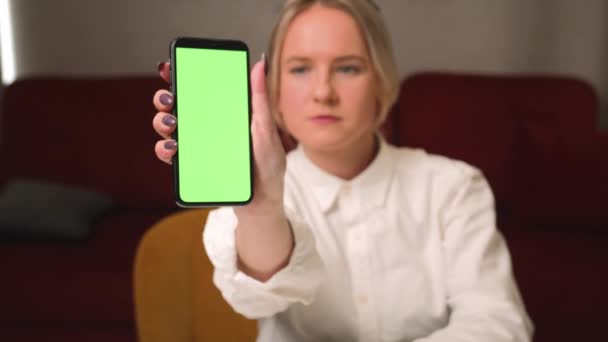 Stock Video Frau zeigt Smartphone mit leerem grünen Bildschirm chromakey zu Hause — Stockvideo