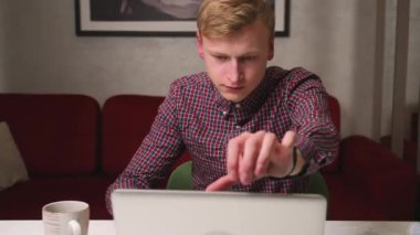 Gülümseyen beyaz iş adamı dizüstü bilgisayarında araştırma yapıyor. Bilgisayarı kullanan profesyonel bir genç ofis masasında oturuyor. Dizüstü bilgisayarda çalışan serbest çalışan meşgul bir işçi..