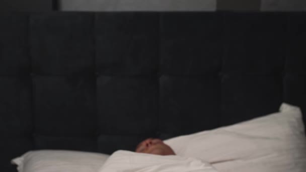 Vooraanzicht van geschokte jonge blanke homoseksuele man verslapen en opstaan snel terwijl liggend in bed. — Stockvideo