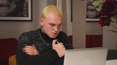 Ev ofisinde dizüstü bilgisayara bakan yorgun ve üzgün bir homoseksüel. İşindeki hataları düşünen üzgün bir adama yaklaş. Laptop görünümlü üzgün bir gencin portresi. Dizüstü bilgisayarda çalışan depresif bir çalışan.