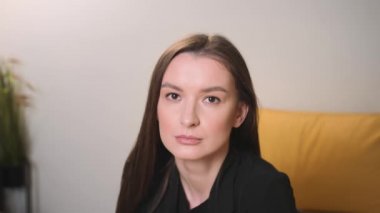 Kendine güvenen genç ve çekici bir iş kadınının portresi kameraya bakıyor.