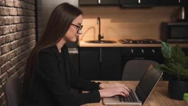 Молодая бизнесвумен в очках, печатающая на ноутбуке, работающая в интернете, улыбающаяся женщина с ноутбука, работающая в Интернете дома или на работе. — стоковое видео