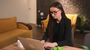 Gözlüklü genç bir kadın evinde ya da iş yerinde bilgisayarında mola veriyor. İş kadını ev ofisinde dizüstü bilgisayar kullanmayı bırakıyor. Mutlu serbest çalışan evde dizüstü bilgisayar işini bitirir.. 