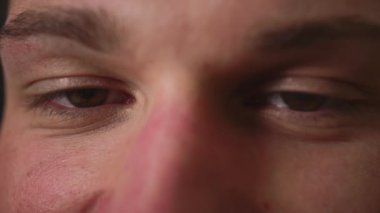 Erkek gözlerine yakın, adamın güzel kahverengi gözleri var. Doğal Güzellik. Adam gülümsüyor. Yavaş çekim.